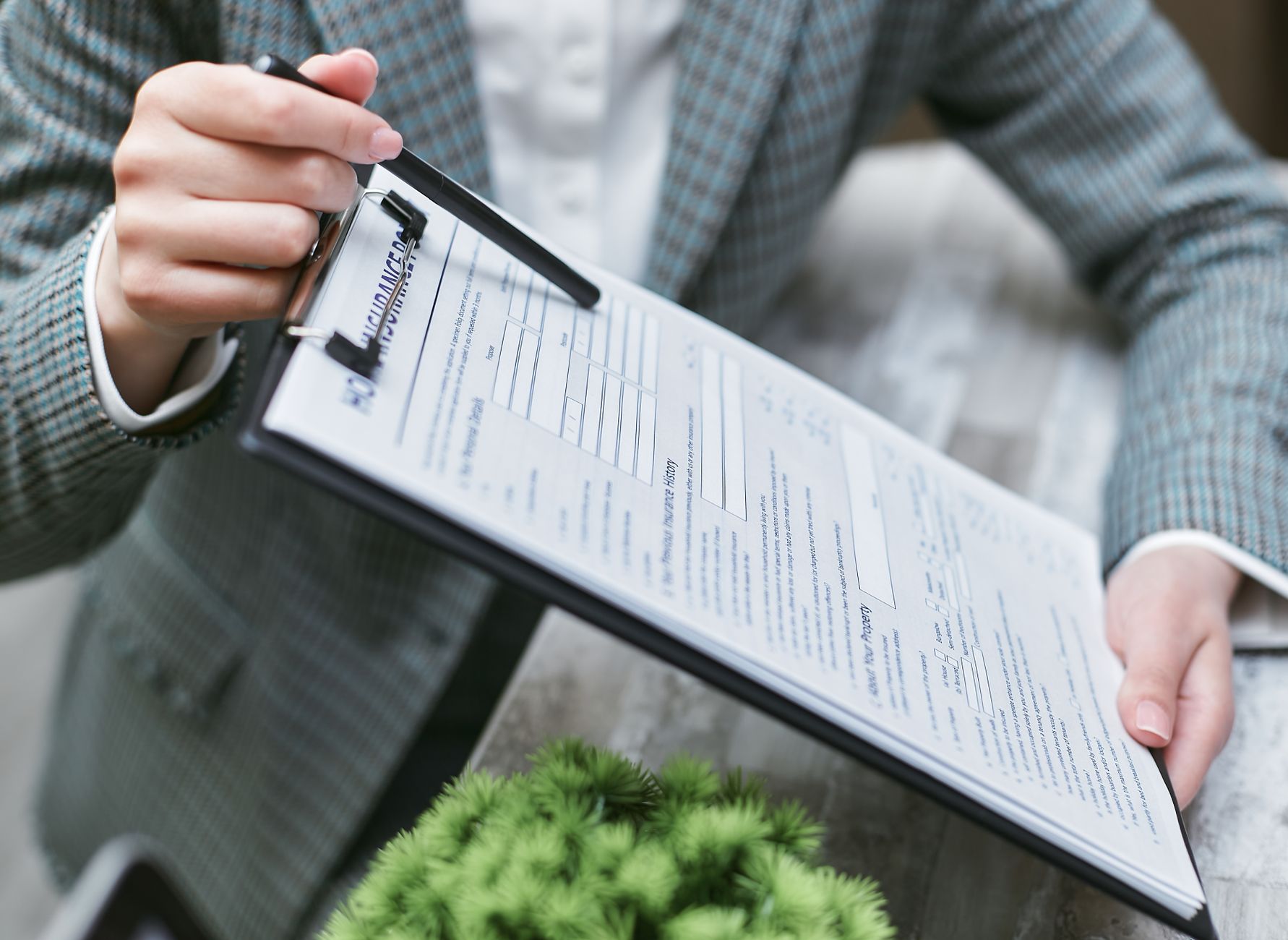 Hand holding a clipboard with an insurance document